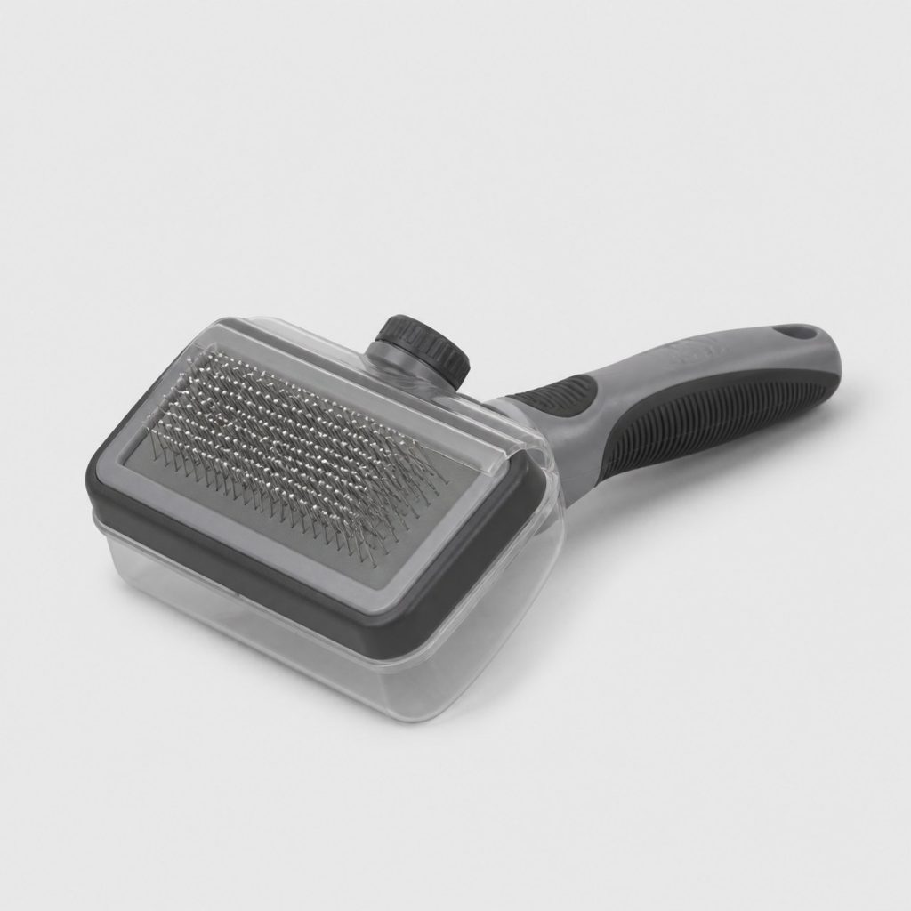 Brosse pour chien à picots rétractables et réservoir intégré, vue de trois quarts