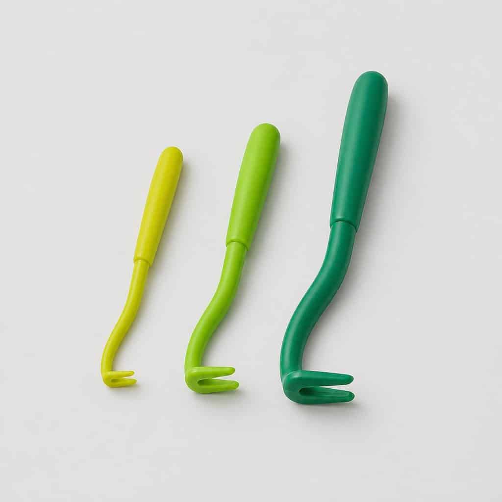 Lot de trois crochets tire-tiques de tailles croissantes alignés sur fond blanc